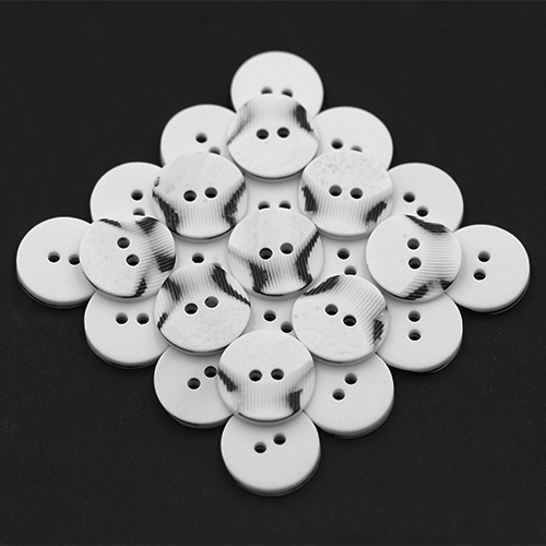 19304 Sullivans 15mm Round Plastic Button 2 Hole With 2 Textured Patterns - White With A Splash Of Black -
